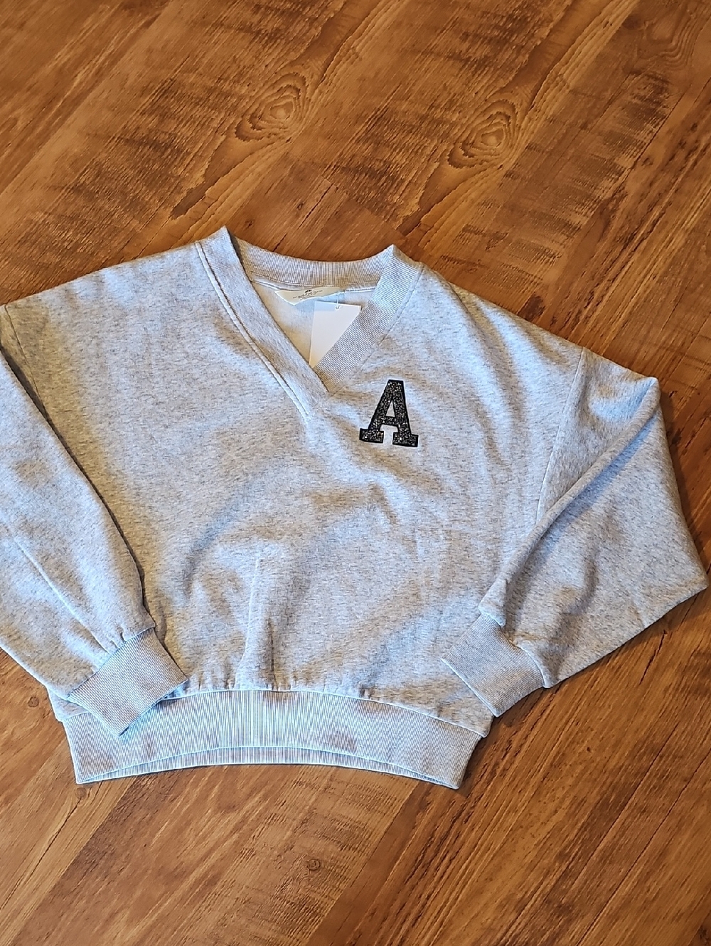 H&M Light Gray V-Neck Sweatshirt with Black Appliqué